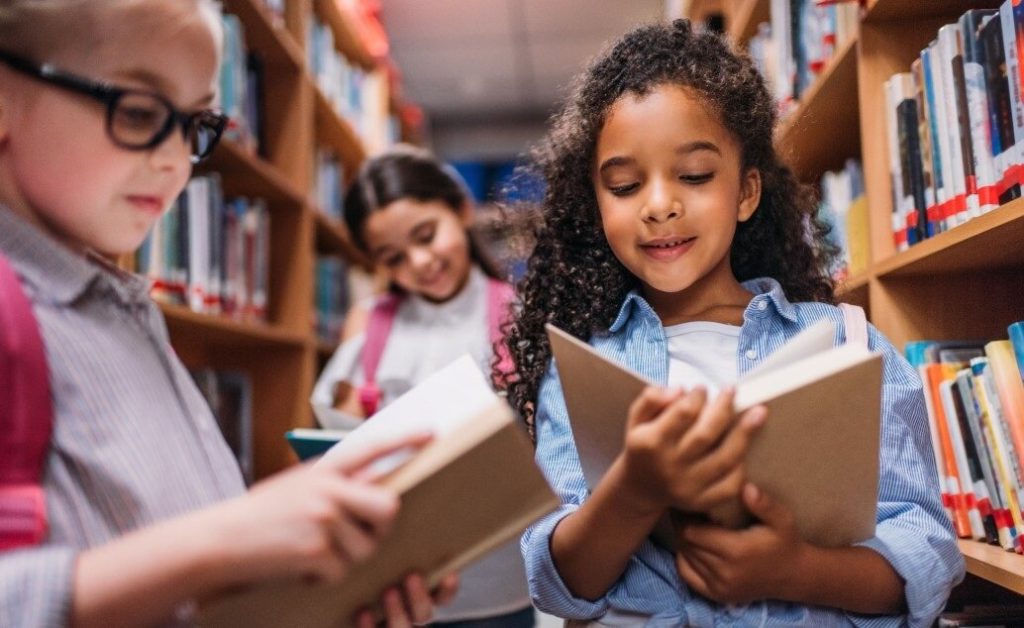Children reading books in a library.