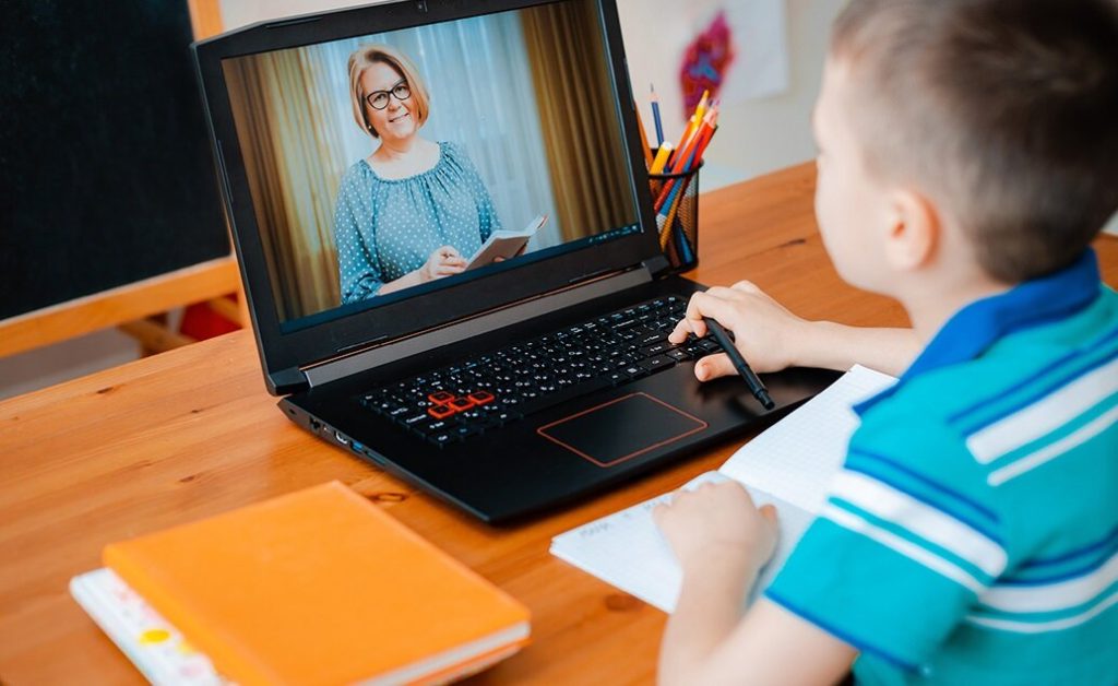 Child participating in an online class on a laptop.