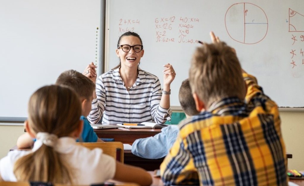 A female teacher leads a math lesson in a classroom with students.