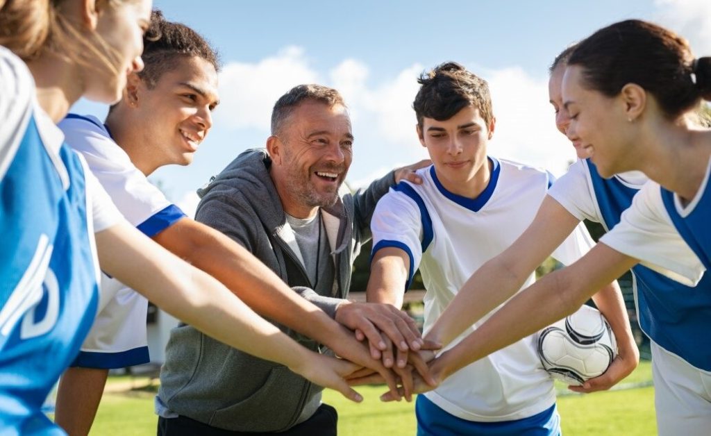 Group of people with a soccer ball, possibly a team.