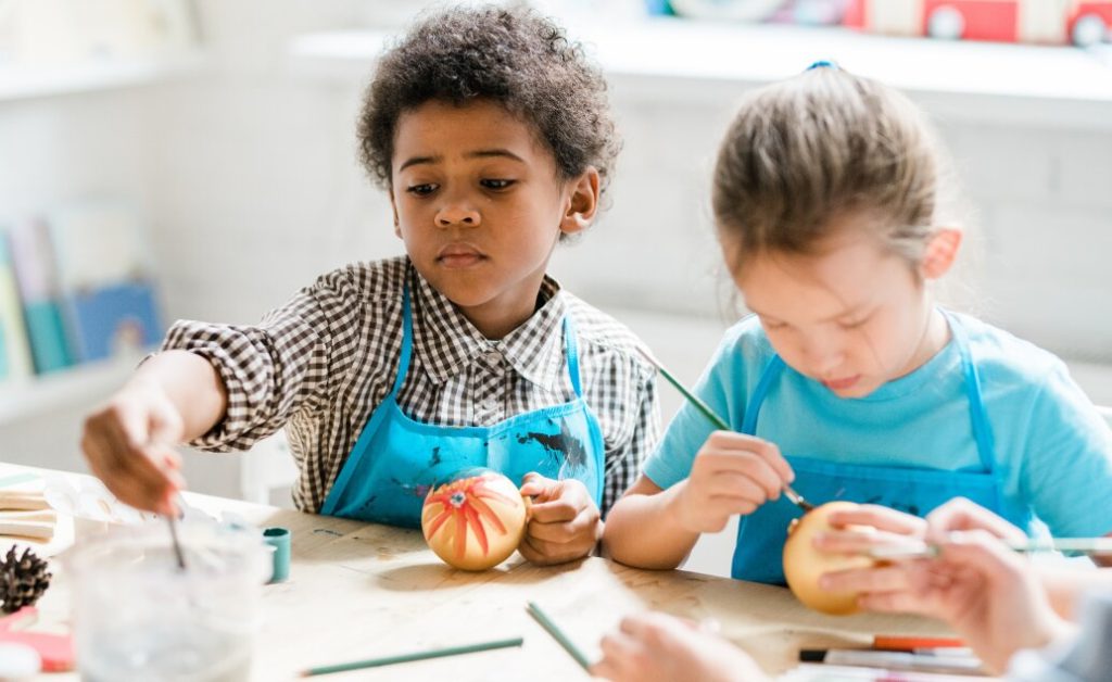 Two children painting at a table.