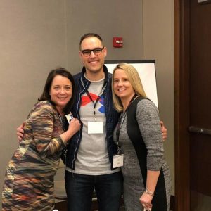 Three smiling people pose for a photo