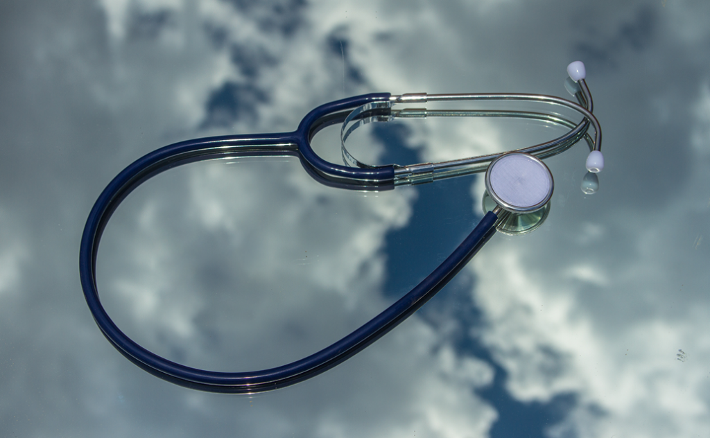 Stethoscope lying against an image of a cloudy sky