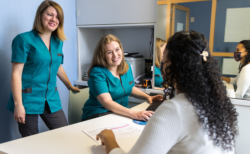 Two healthcare administrators help a patient