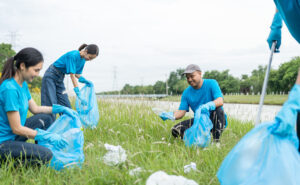 A group of volunteers outside with garbage bags, picking up trash