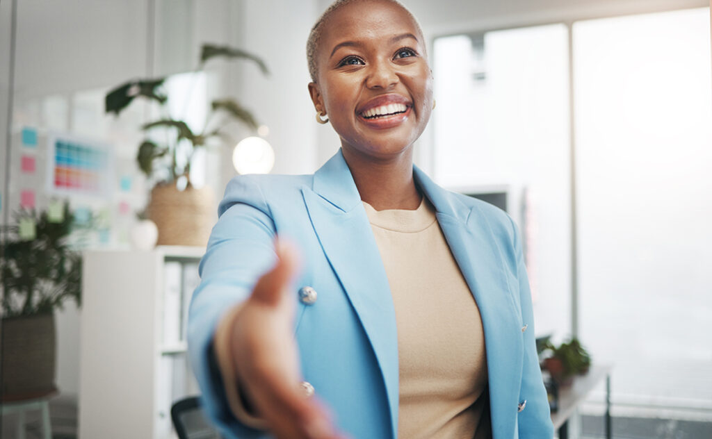 Woman about to shake hands with an interviewer before an interview