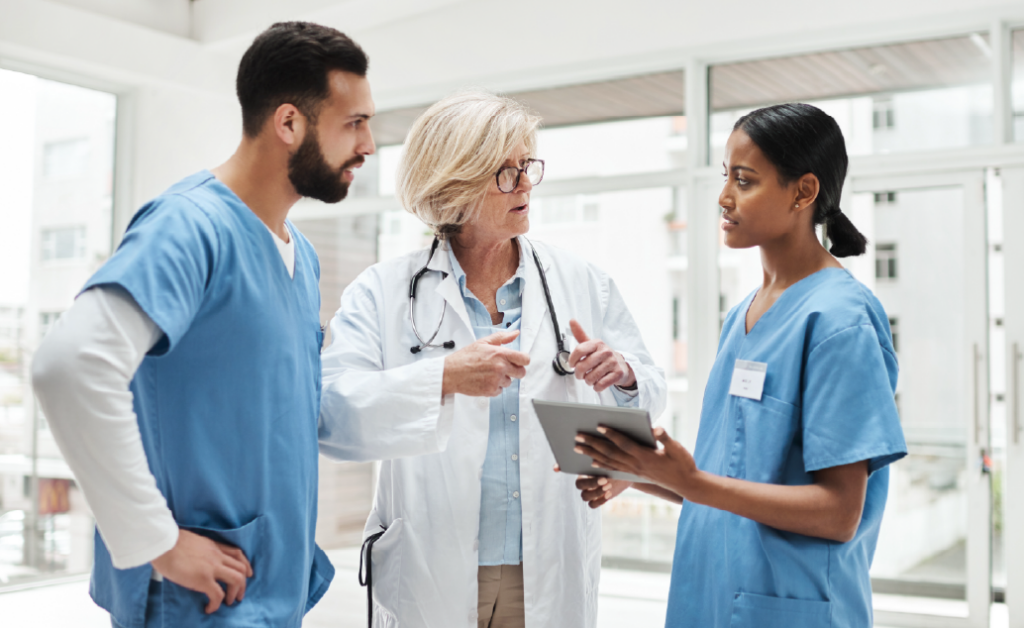 Picture of a healthcare professional and two nurses discussing a patient's chart.